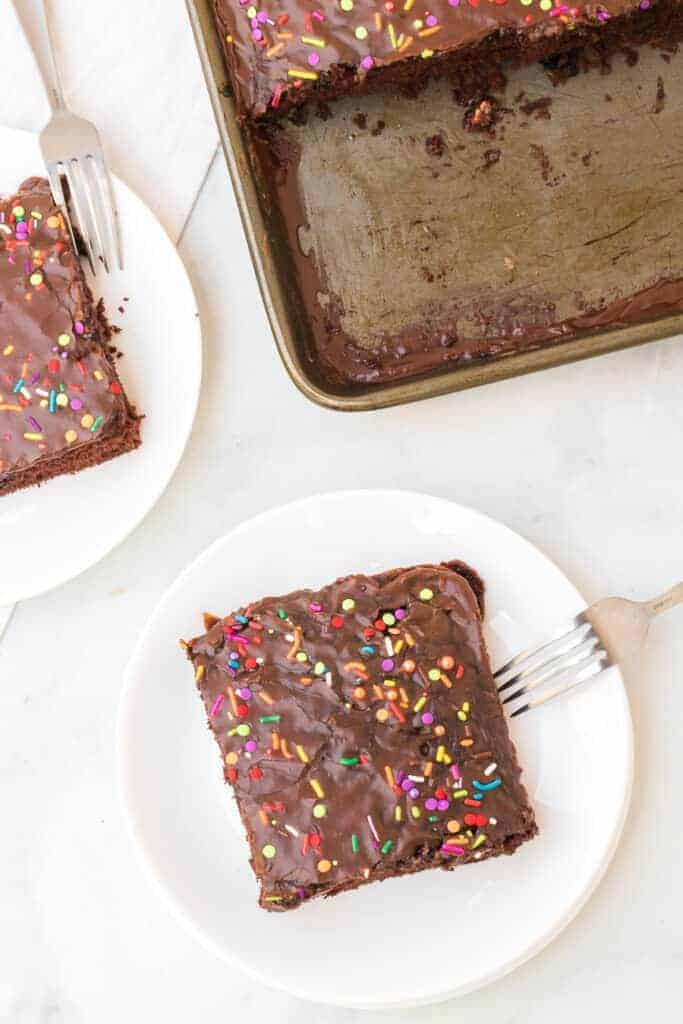 chocolate sheet cake with sprinkles on top on a plate