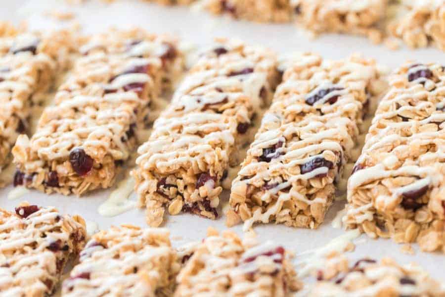 White chocolate and cranberry granola bars are the perfect grab-and-go snack, and they are so simple to make at the beginning of the week to have on the go all week long. I love a granola bar because it's packed with nutrients and vitamins, and these ones taste indulgent even though they're full of nutritious ingredients! #granolabars #homemadegranolabars #cranberrywhitechocolate #proteinbars #snack #homemadesnack #snackrecipes