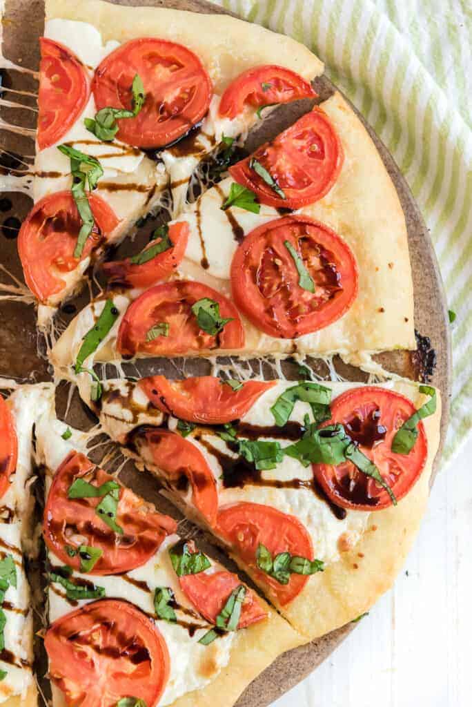 tomatos and balsamic reduction spread over a classic margarita pizza