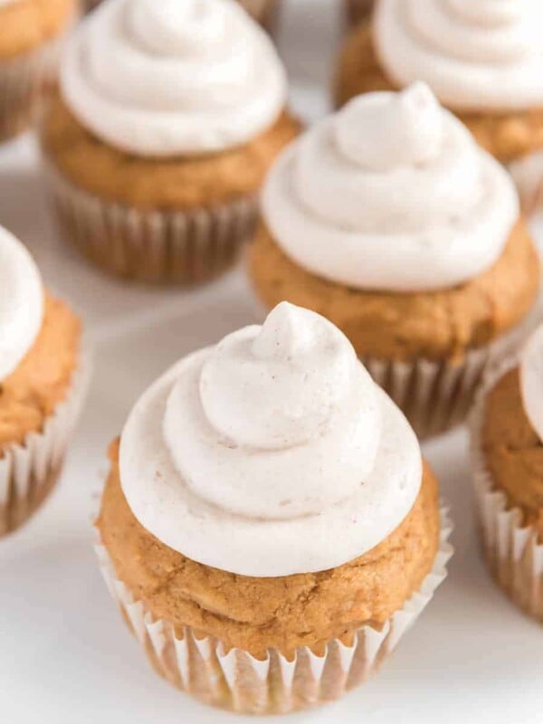 light golden pumpkin cupcakes with a cream colored and cinnamon speckled icing