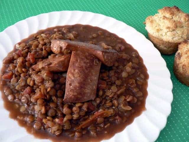 spicy lentils with sausage on a white plate