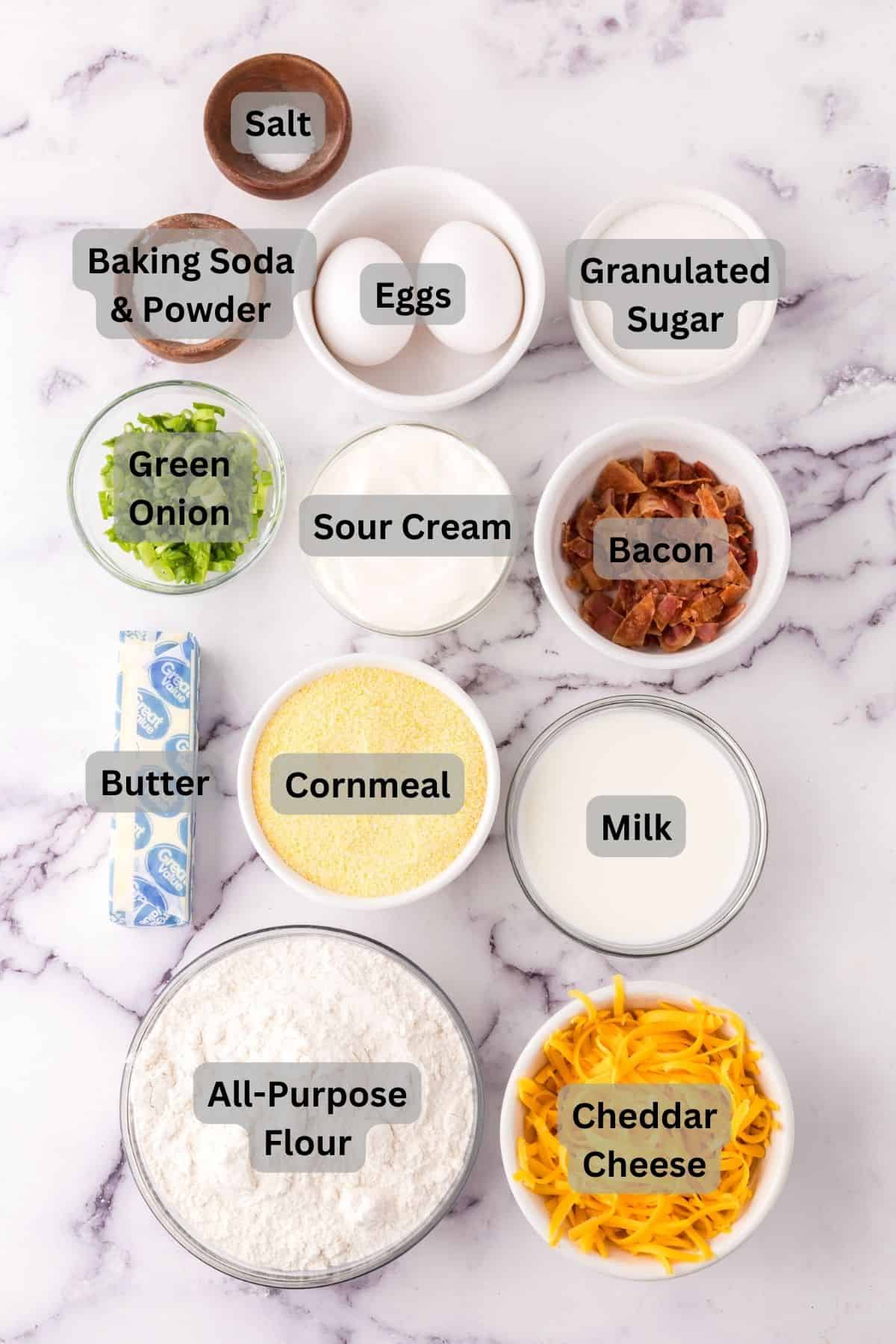 portion bowls each with labeled raw ingredients to make cheddar bacon cornbread muffins.