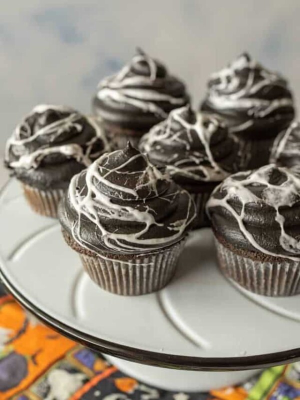 spiderweb Halloween cupcakes on a white cake stand