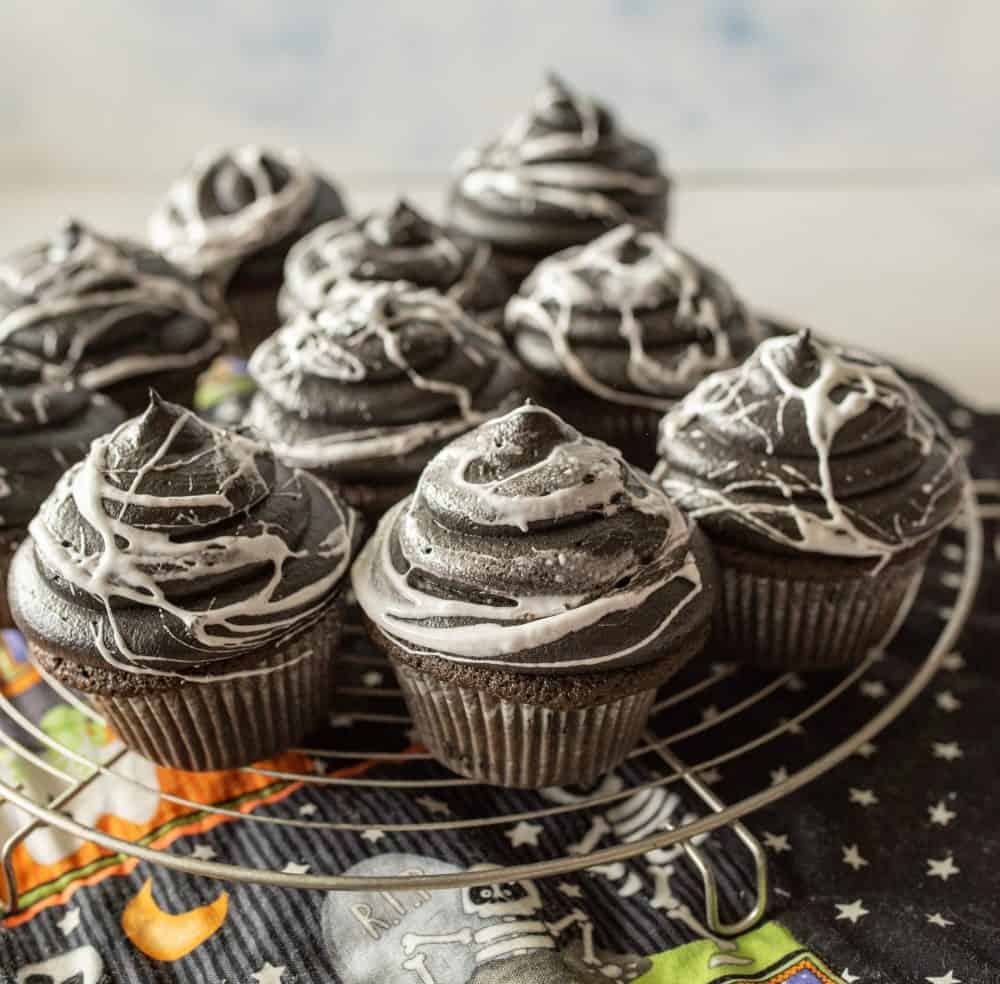 spiderweb Halloween cupcakes on a wire rack
