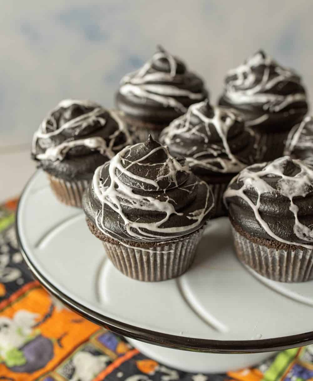spiderweb Halloween cupcakes on a white cake stand