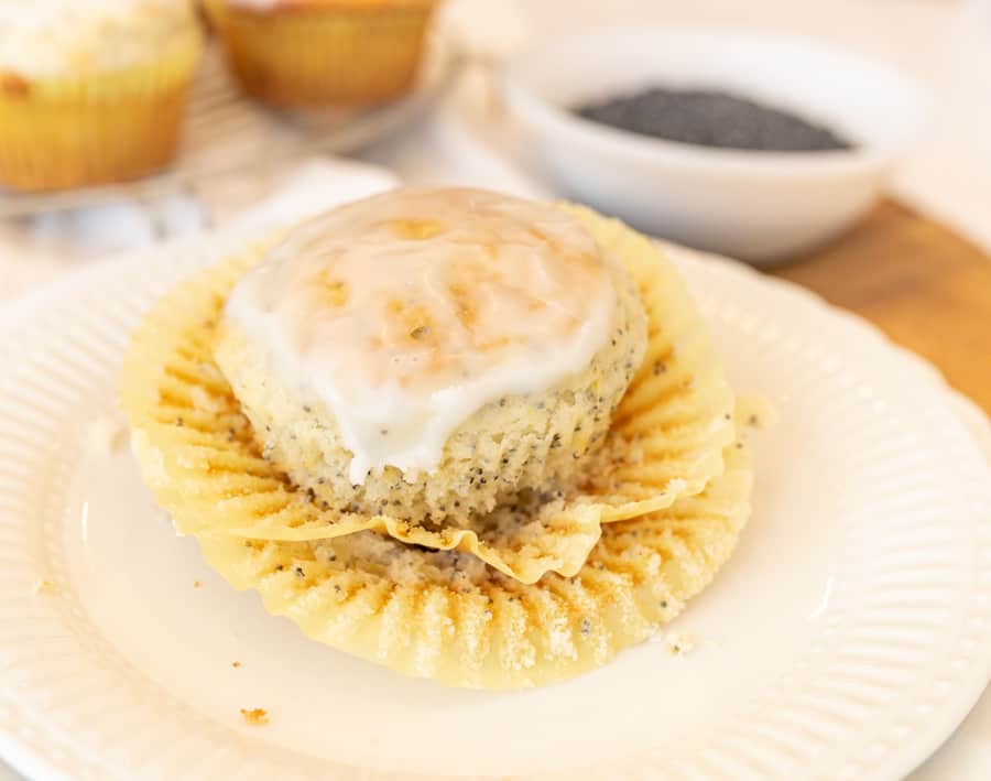 A picture of a lemon poppy seed muffin, unwrapped and on a plate. 