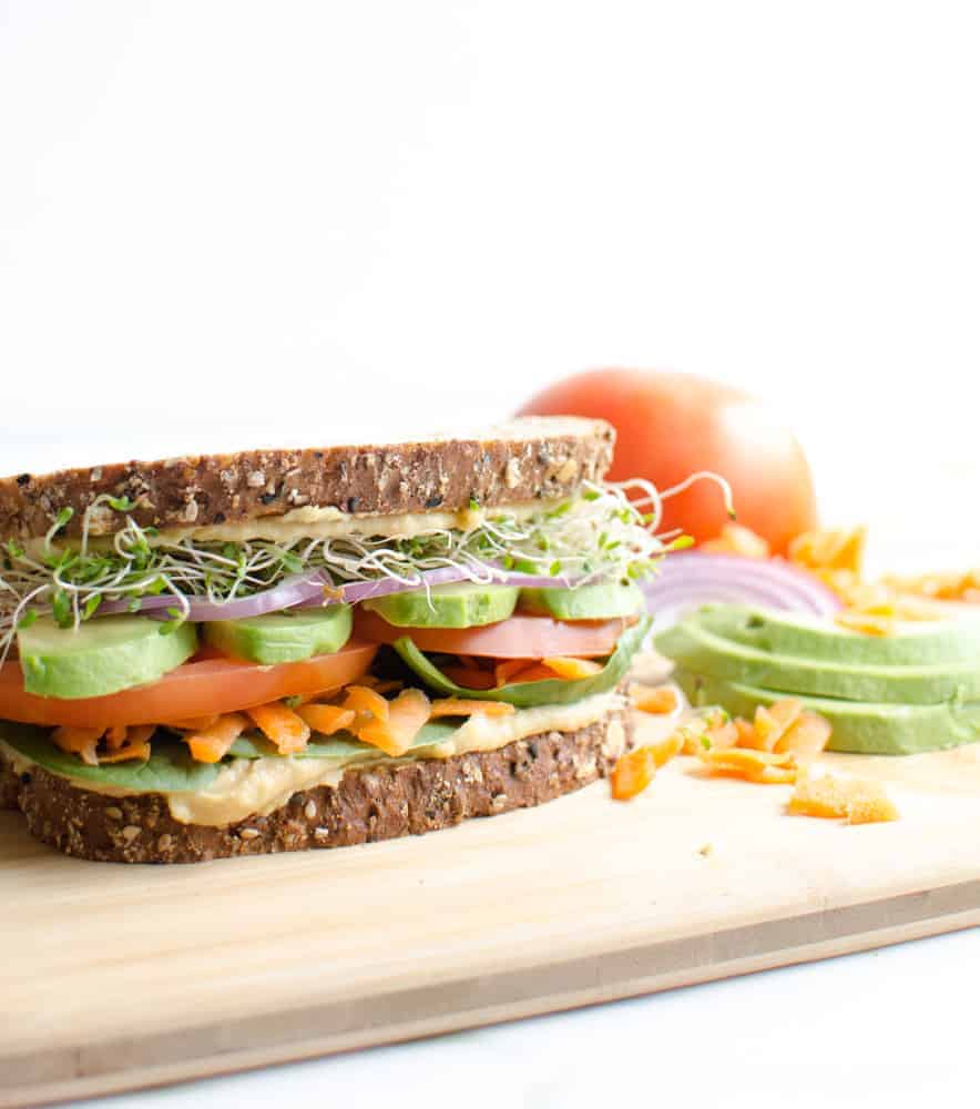 The Ultimate Hummus and Veggie Sandwich surrounded by the ingredients. 