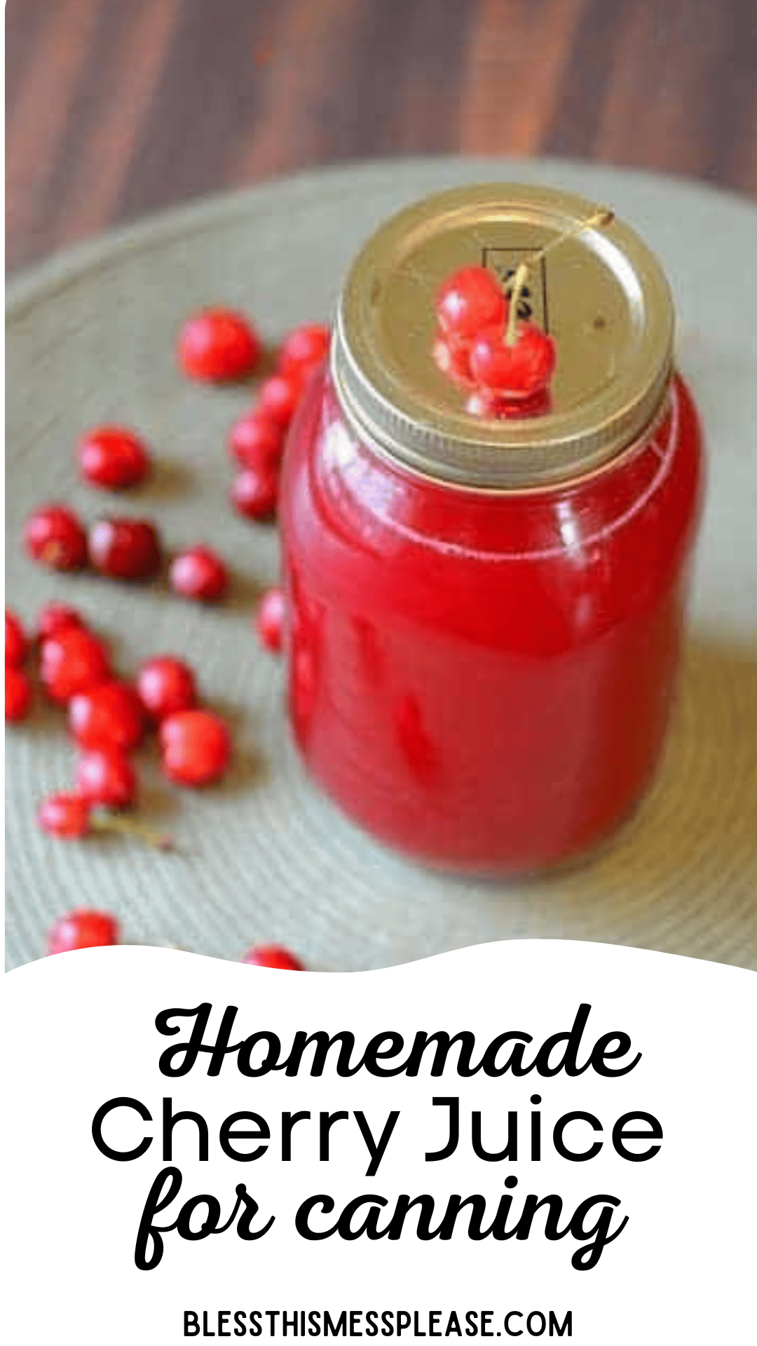 A jar of homemade cherry juice with a metal lid rests on a gray surface, surrounded by fresh red cherries. The text Homemade Cherry Juice for canning graces the bottom.