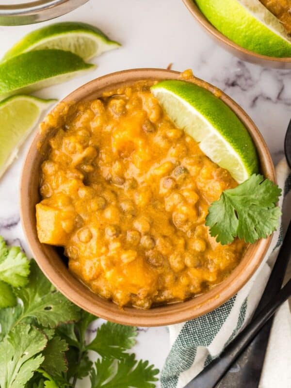Lentil curry garnished with limes and clilantro.