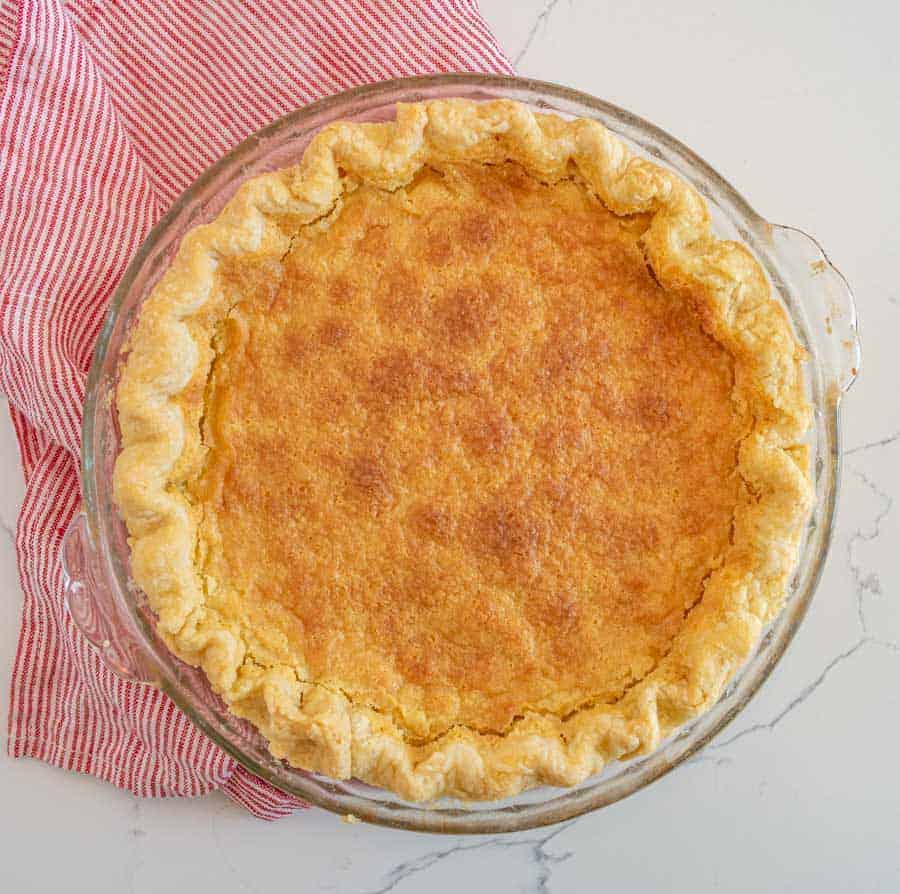 whole buttermilk pie, overhead image inside the circular clear glass pie plate.