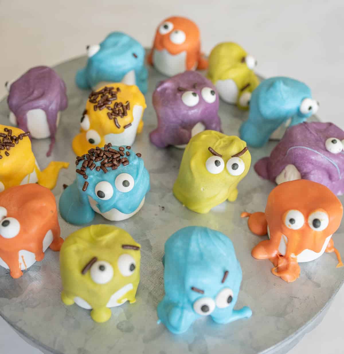 Many marshmallow monsters on a metal cake stand