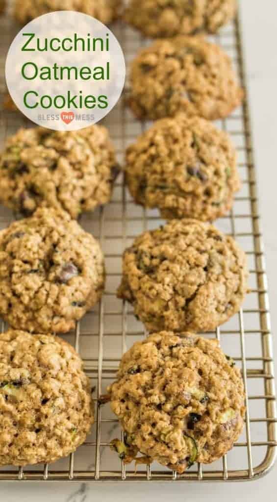 Zucchini oatmeal cookies arranged on a cooling rack. The cookies are golden brown with visible oats and zucchini shreds. Text overlay reads Zucchini Oatmeal Cookies with a small logo below.