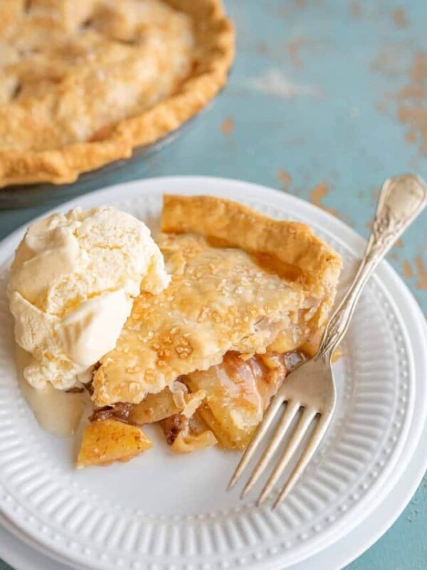 a slice of easy apple pie on a white plate with vanilla ice cream