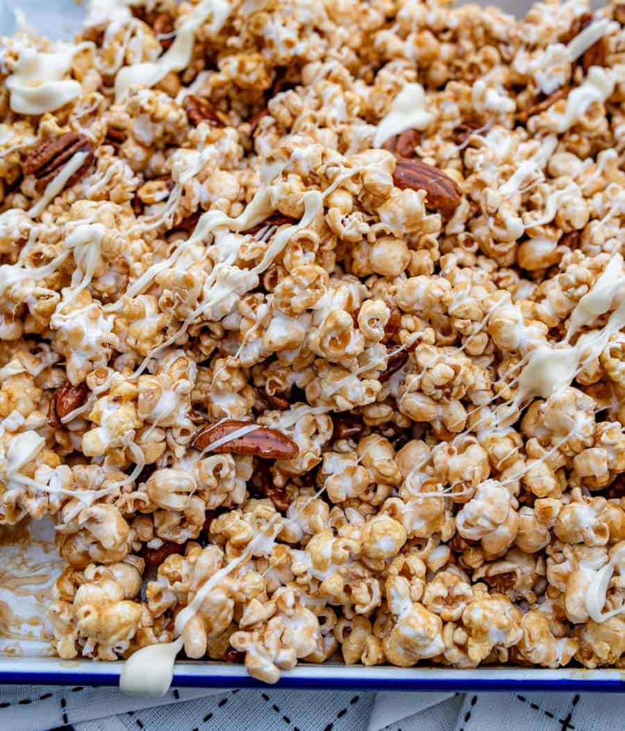 close up view of a pan of cinnamon caramel corn drizzled with white chocolate