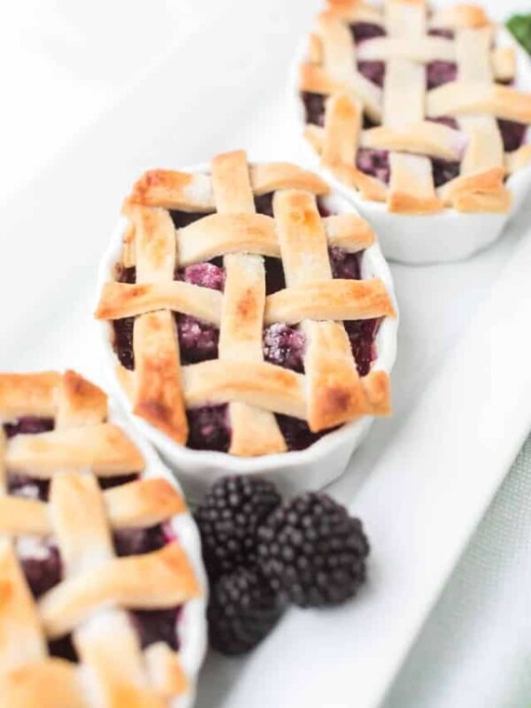 small white dishes filled with blackberry pie filling and a lattice crust top