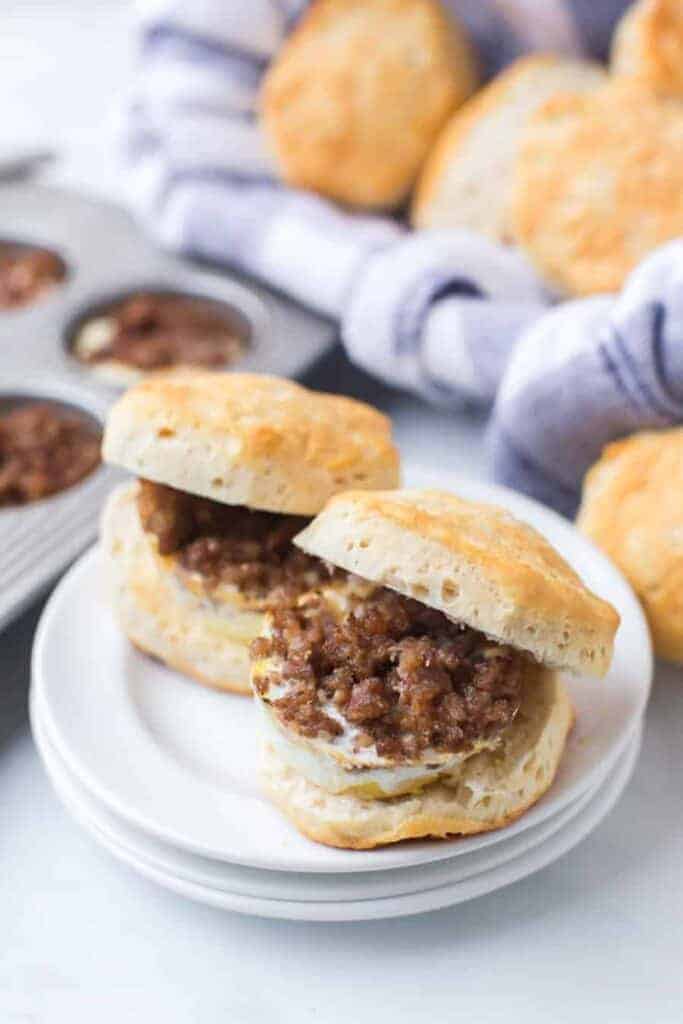 a plate of home made biscuits with ground sausage and egg in the middle