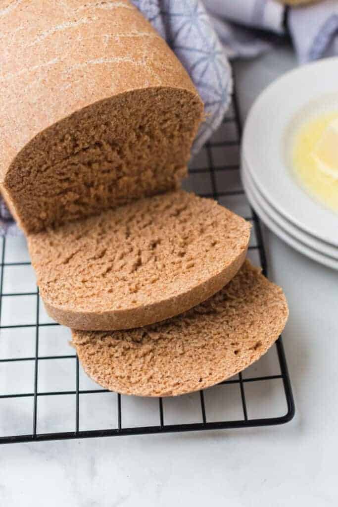 whole wheat bread on a cooling rack sliced
