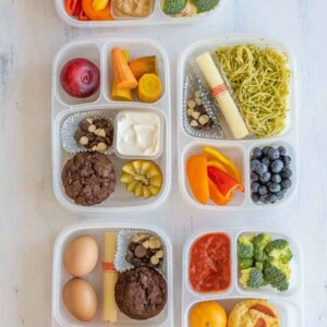 many different tupperware with compartments for different lunch ingredients and chocolate milk on the side