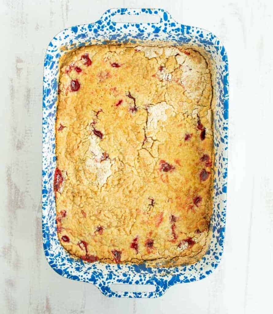 top view of cherry dump cake in a white and blue baking dish