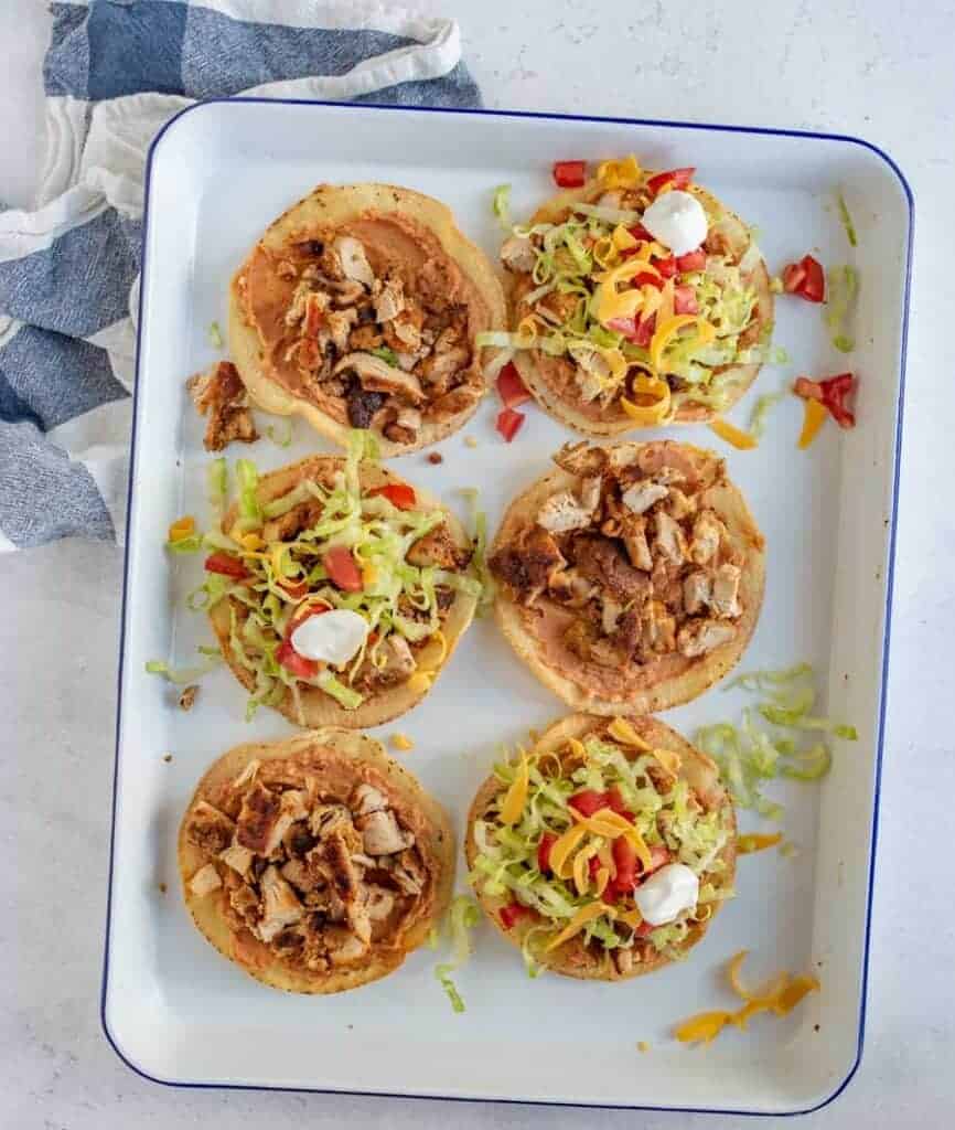 top view of six tostadas on a white square plate