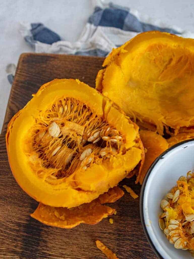 half of a pumpkin on a cutting board