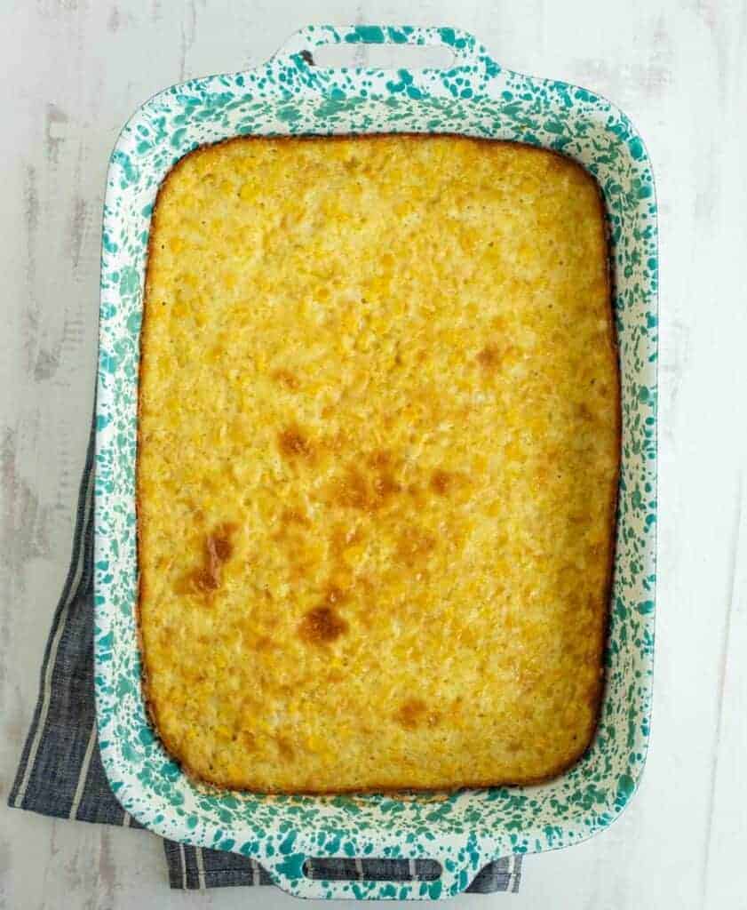 top view of corn pudding in a green and white baking dish