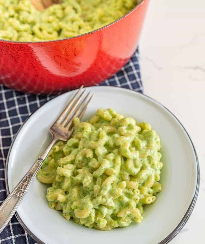 green mac and cheese on a white plate