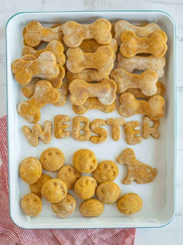a baking dish of homemade dog treats with bones and some in the shape of the letters WEBSTER