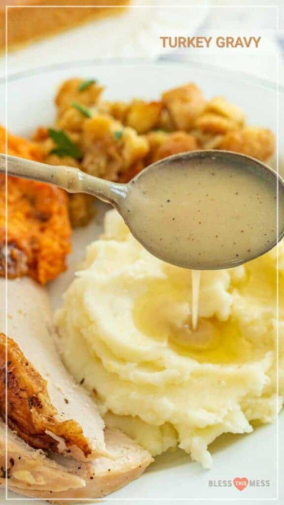 spoon full of gravy dripping over mashed potatoes