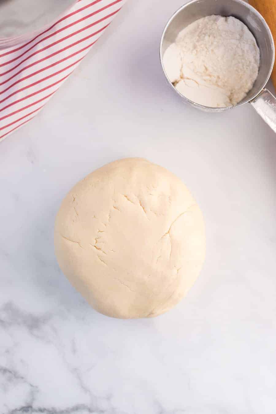 a ball rolled out on a floured table of shortbread cookie dough