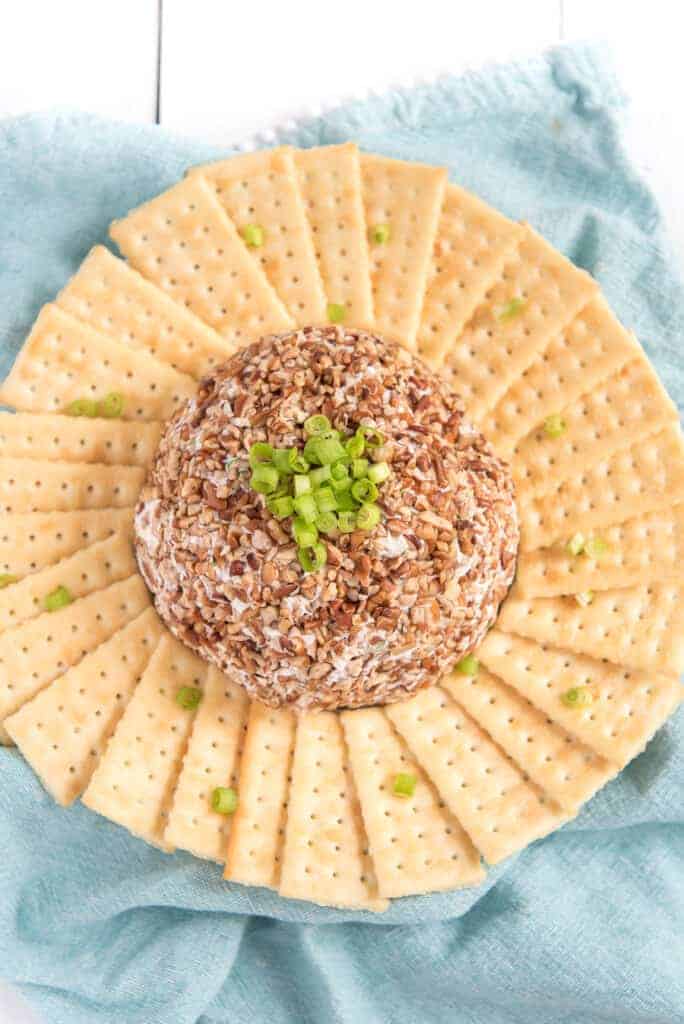 top view meat and onion cheese ball in the center of a plate with butter crackers all around