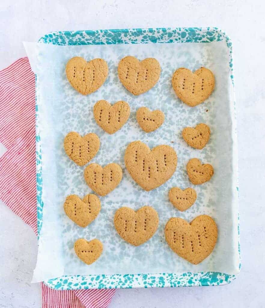 graham crackers in the shape of little hearts with fork punctures in them a parchment lined baking dish