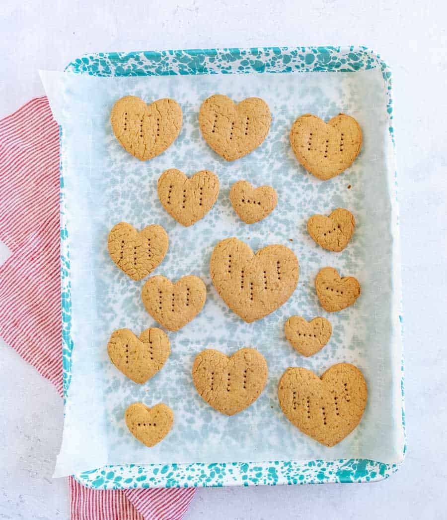 graham crackers in the shape of little hearts with fork punctures in them a parchment lined baking dish.