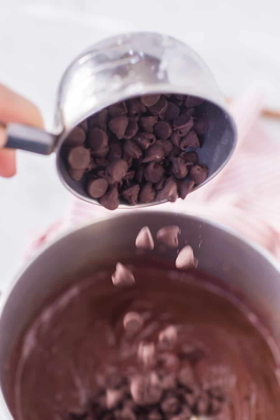 adding chips to chocolate pudding recipe in mixing bowl.