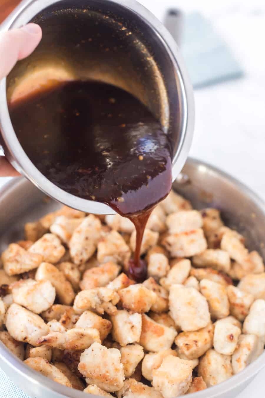 pouring sauce over chicken pieces.