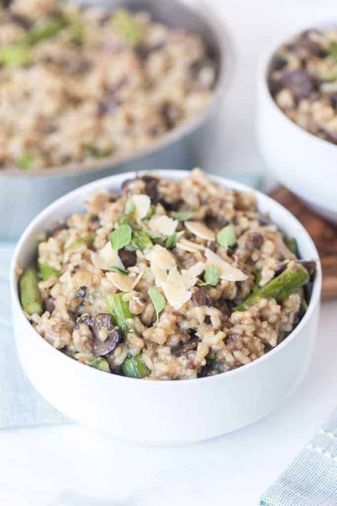 sausage mushroom asparagus risotto in white bowls