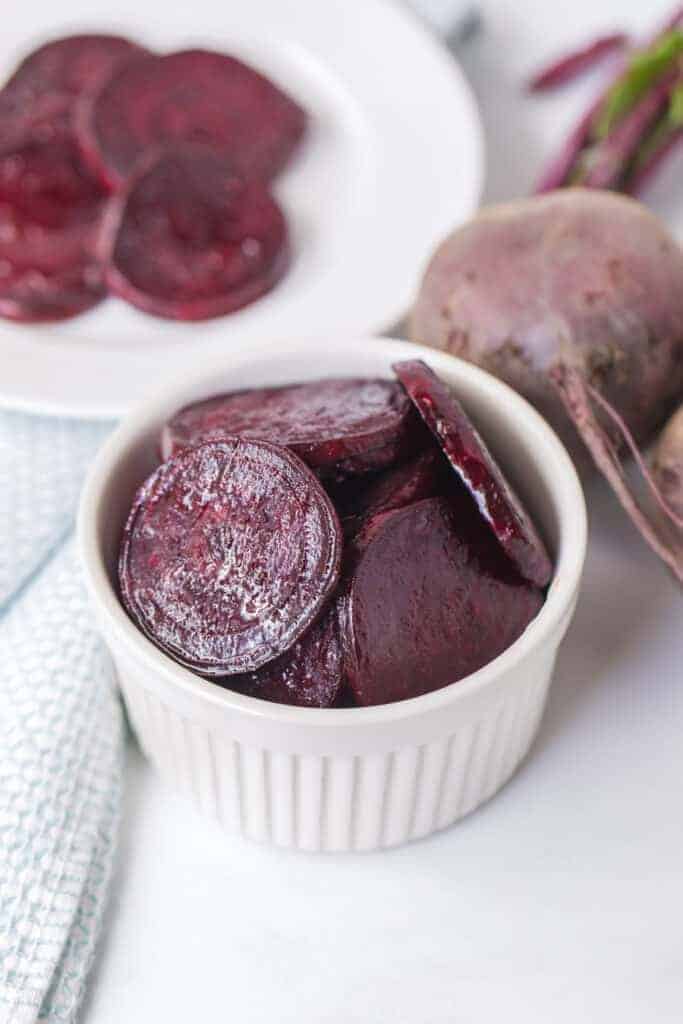 pile of roasted beet slices on a white plate and in a white dish