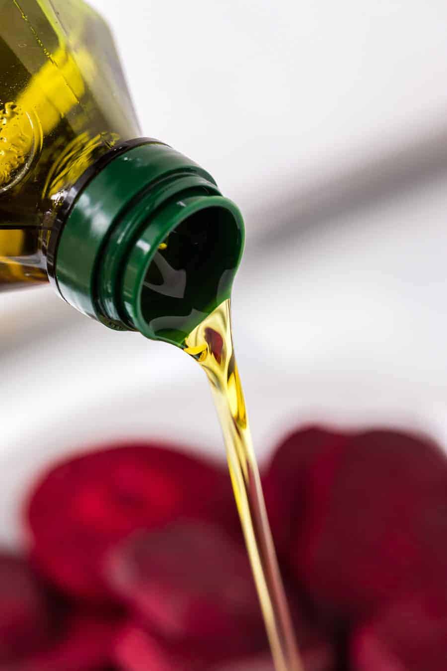 oil being poured onto raw beet slices.