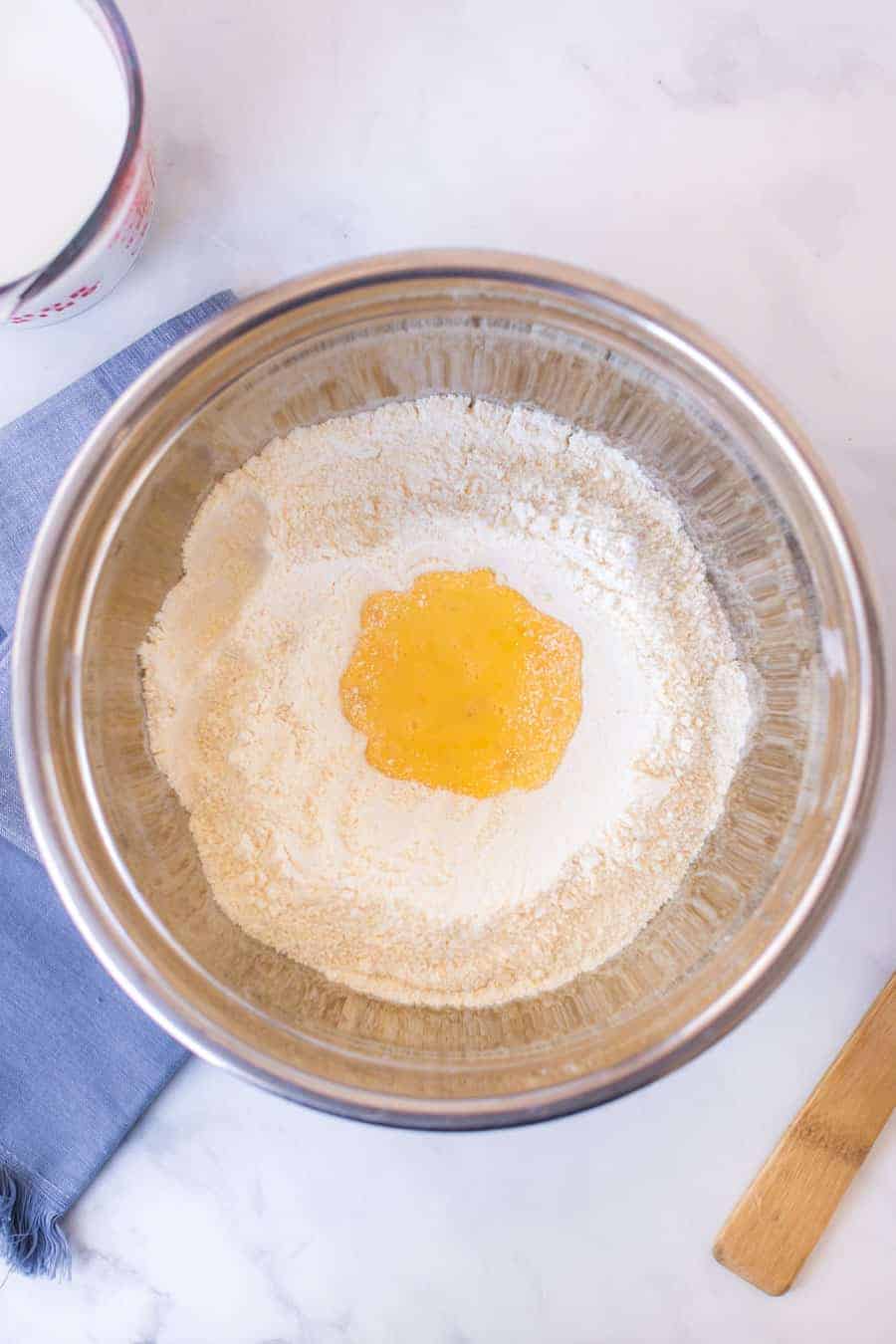 top view of ingredients for cornbread batter in a metal mixing bowl.