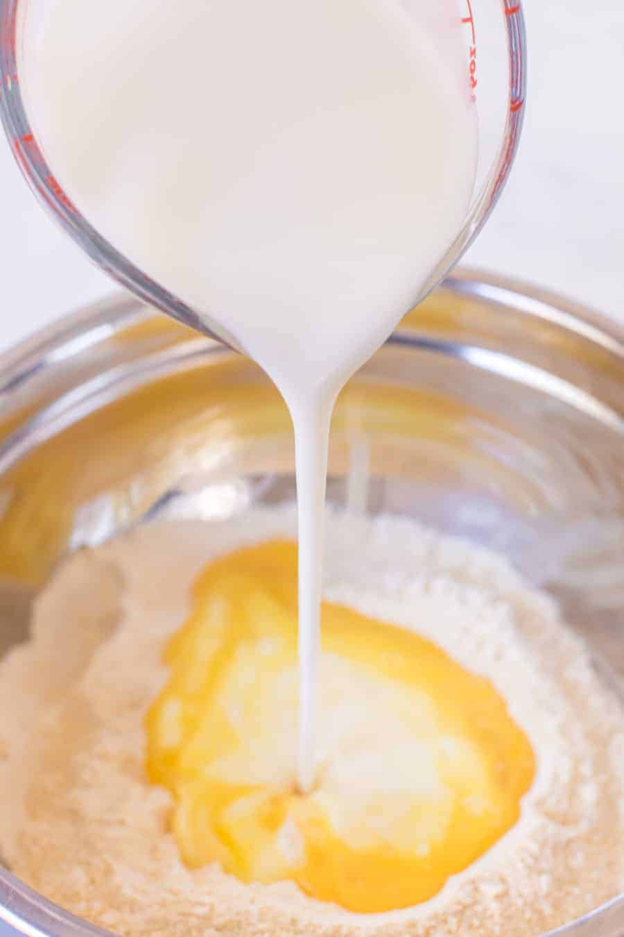 top view of ingredients for cornbread batter in a metal mixing bowl.