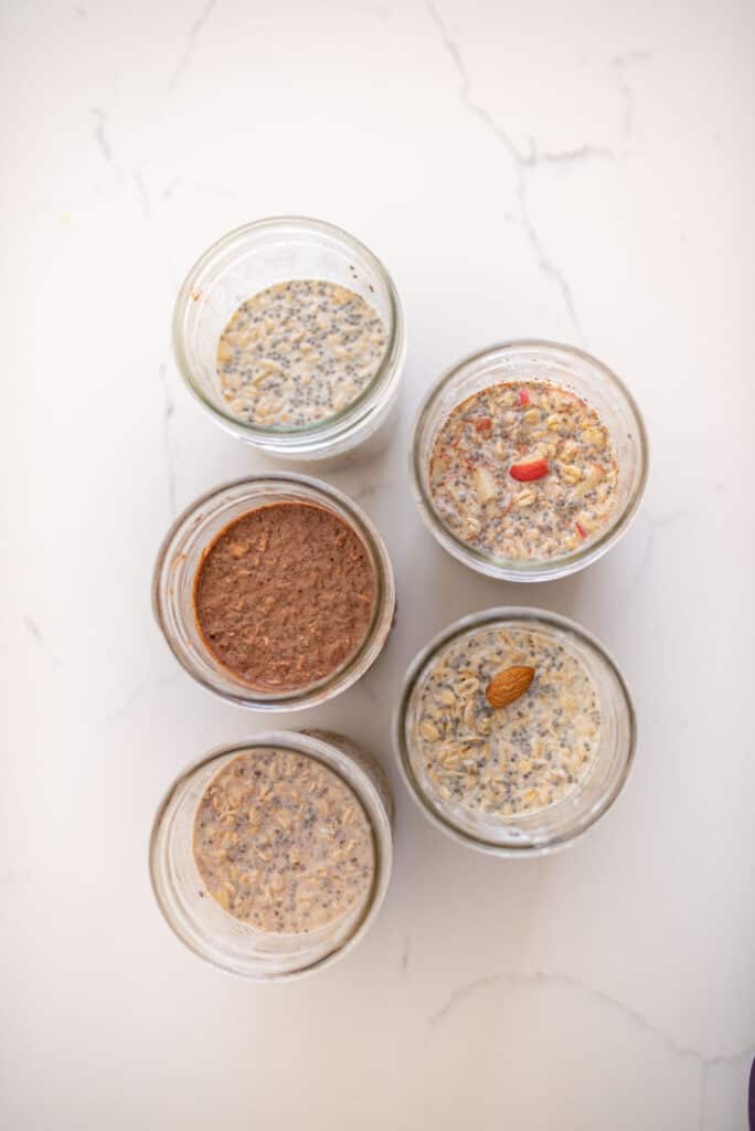 top view of various flavors inside wide mouth mason jars of overnight oats