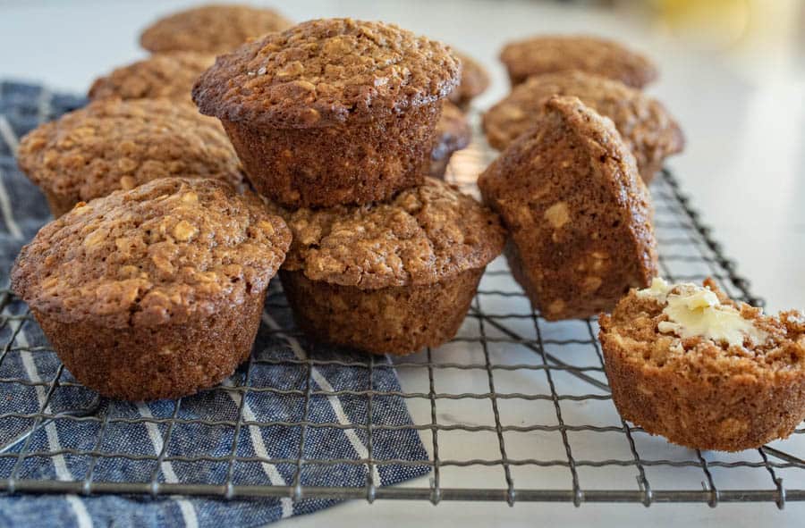 brown sugar oatmeal muffins with butter stacked on cooling rack