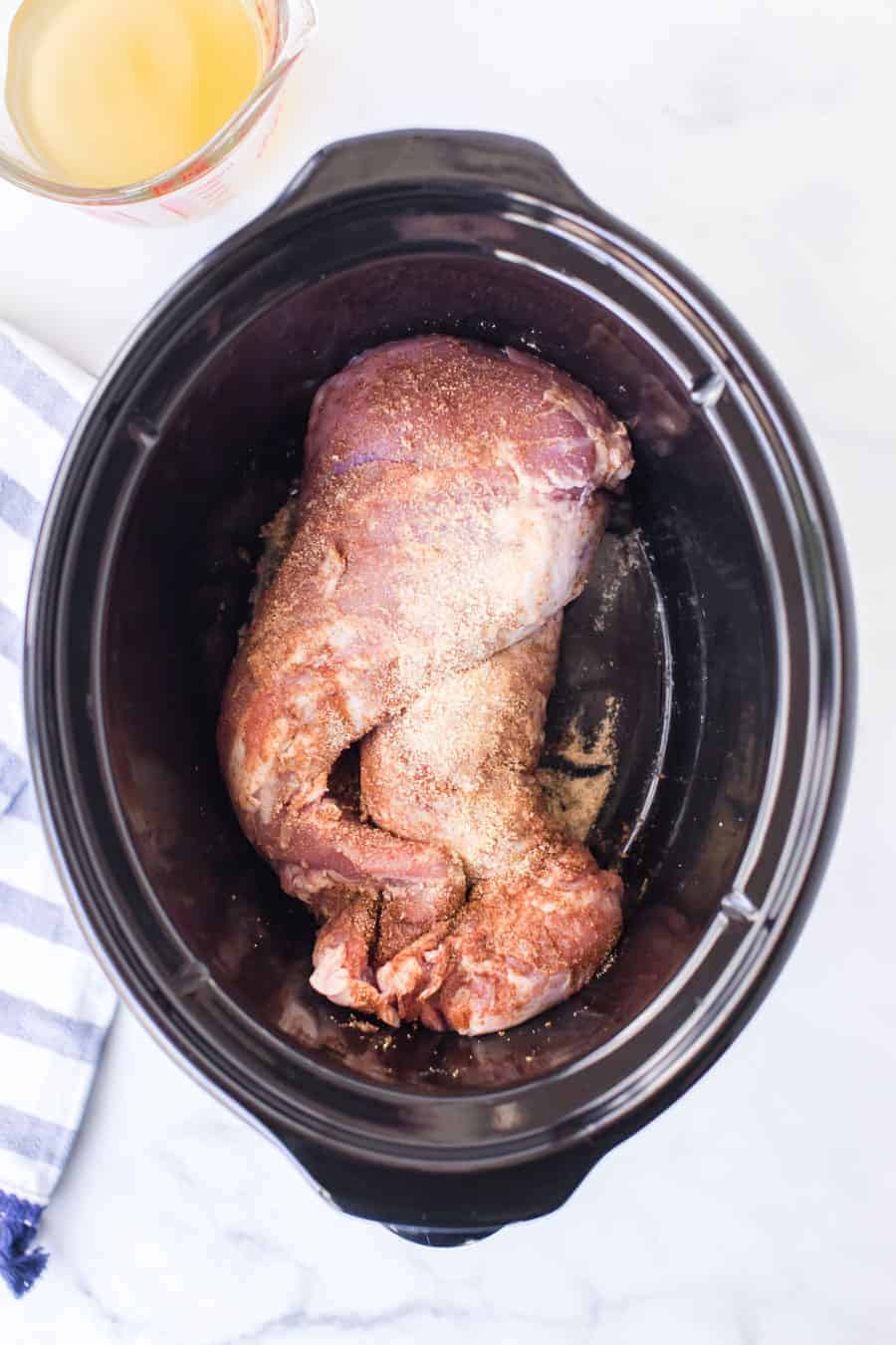 rawpork tenderloin in a crock pot before shredding.