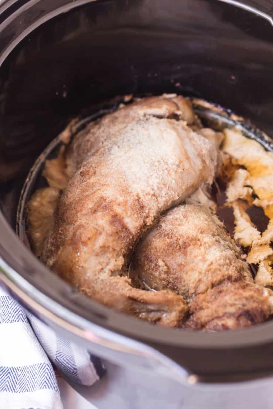 cooked pork tenderloin in a crock pot before shredding.