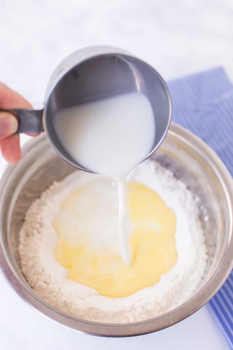 milk over flour in a mixing bowl for dumplings