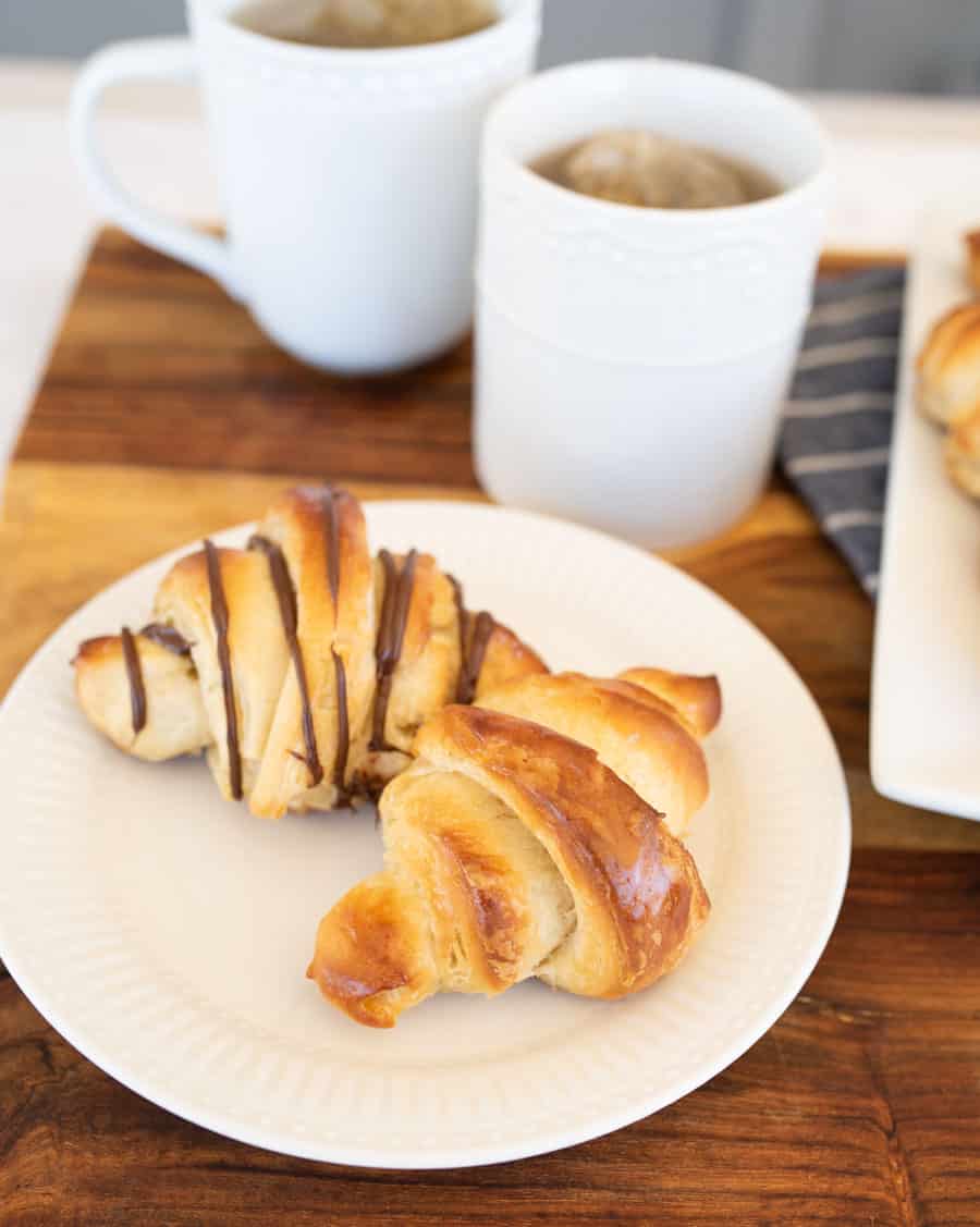 two kinds of croissants on a white plate with tea. 