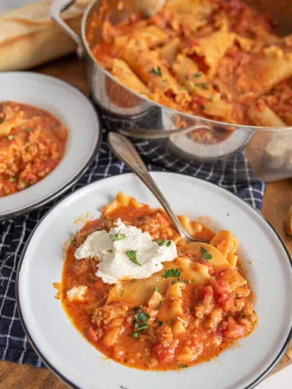 lasagna soup with a dollop of ricotta on top and parsley