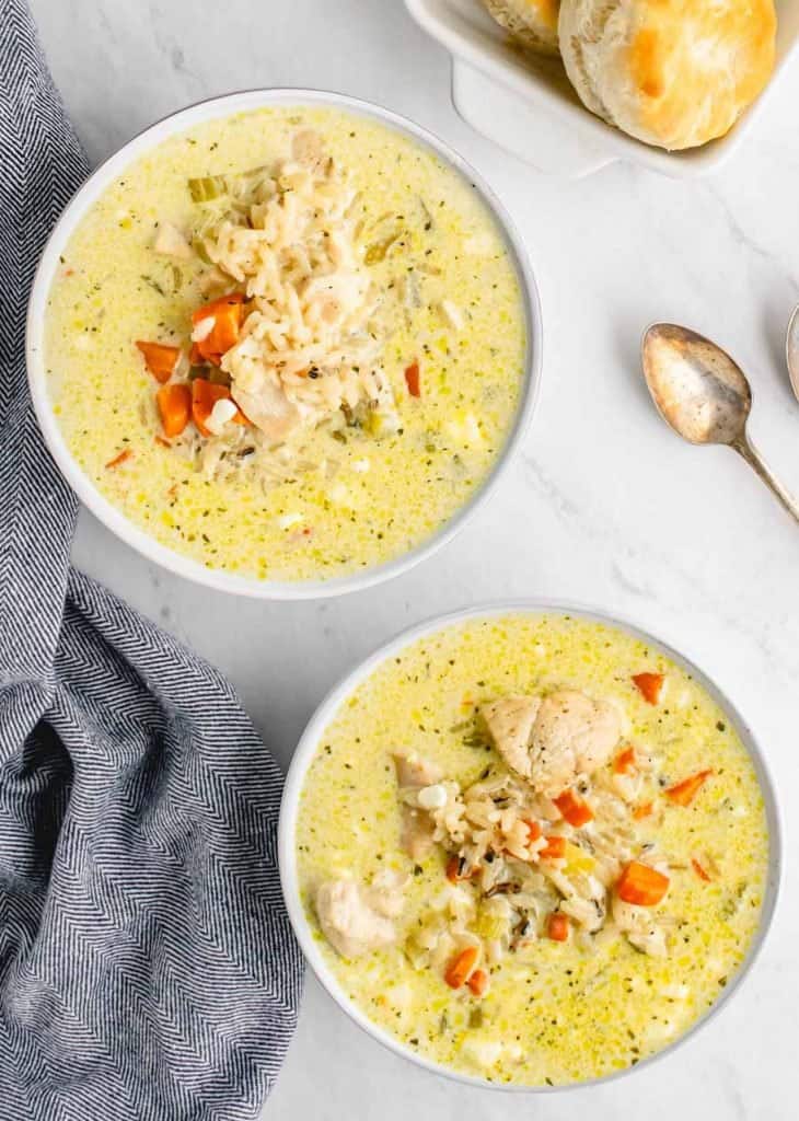 creamy soup with chicken and rice popping out -biscuits in the background.