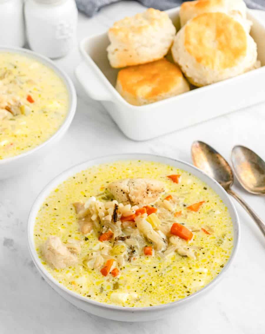 creamy soup with chicken and rice popping out -biscuits in the background.