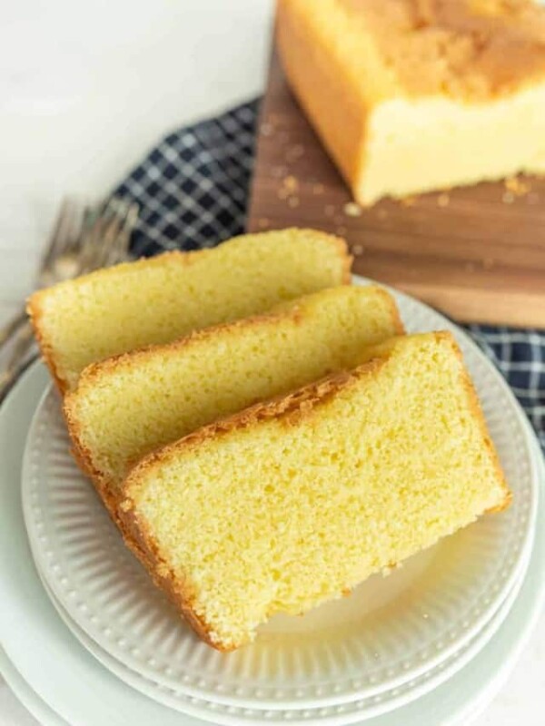 slices of pound cake on a plate with pound cake on a cutting board in the background